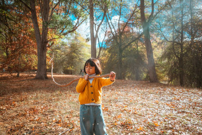 Young woman standing against trees