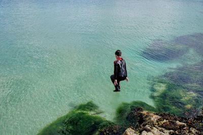 High angle view of man on rock in sea