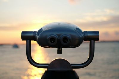 Close-up of camera against sunset