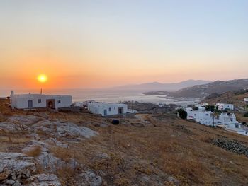 Scenic view of sea and buildings against sky during sunset