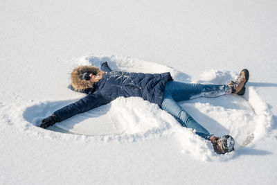High angle view of person lying on snow covered land
