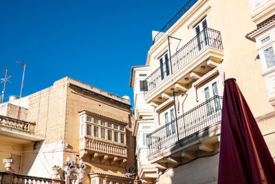Low angle view of buildings against clear blue sky