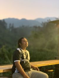 Side view of man sitting on field