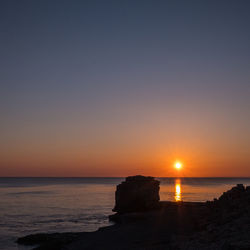 Scenic view of sea against clear sky during sunset