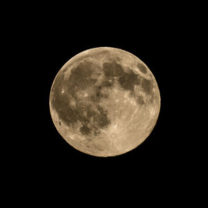 Low angle view of full moon against clear sky at night