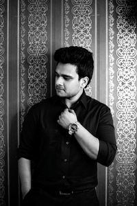 Young man standing against wall