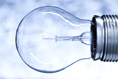 Close-up of light bulb against cloudy sky