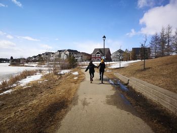 Rear view of people walking on road in winter