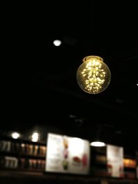 Low angle view of illuminated pendant light at night