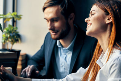 Young man and woman sitting at home