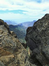 Scenic view of mountains against cloudy sky