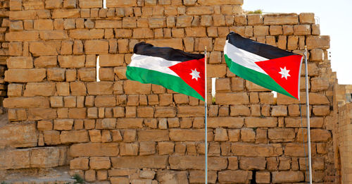 Multi colored flag on brick wall