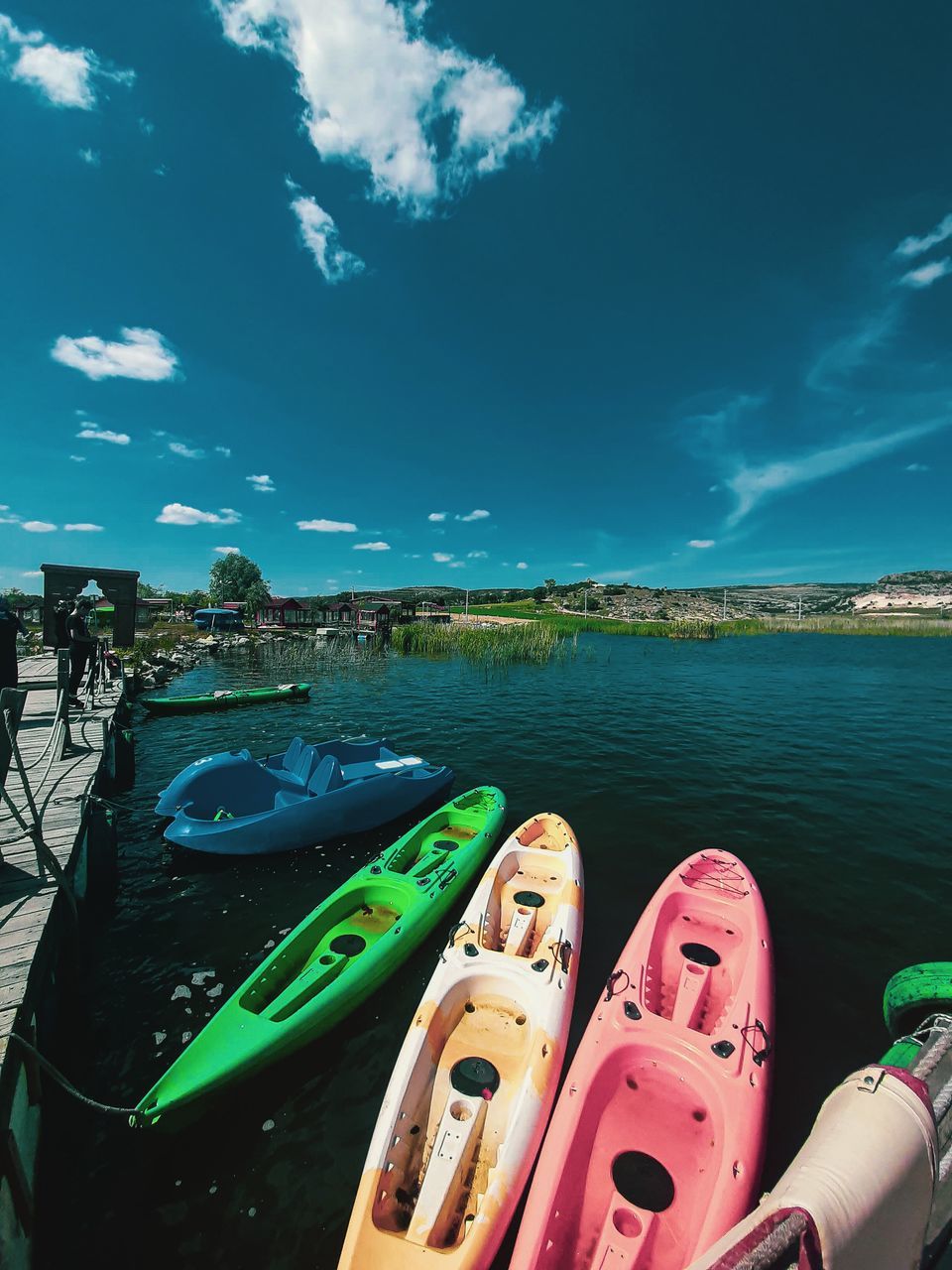 HIGH ANGLE VIEW OF MULTI COLORED BOATS ON LAKE