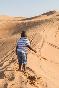 Rear view of man on sand dune