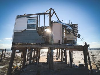 Low angle view of abandoned built structure on beach against sky