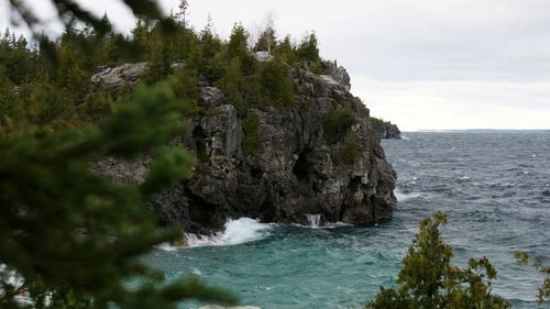 Scenic view of sea and cliff against sky