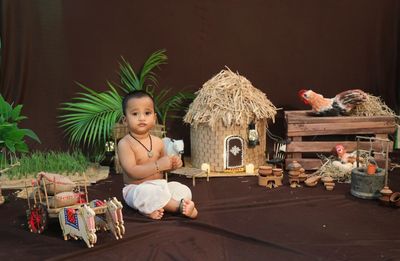 Portrait of cute baby boy sitting on out side of the house 