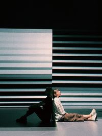 Side view of a women sitting on floor 