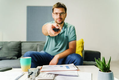 Young man using mobile phone while sitting on table