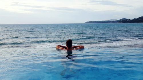 Full length of woman relaxing in sea