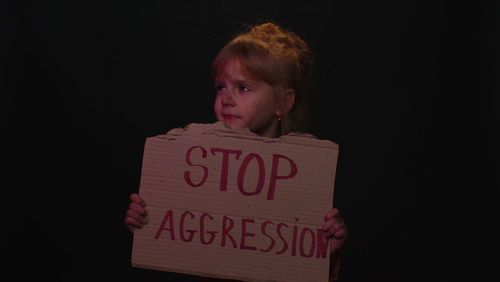 Portrait of young woman with text against black background