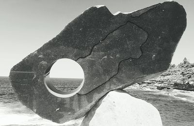 Close-up of rock formation in sea against clear sky