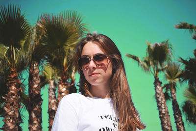 Portrait of young woman wearing sunglasses standing outdoors