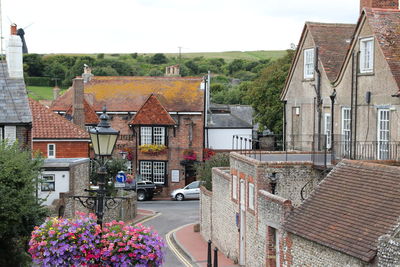 Houses by street in town against sky