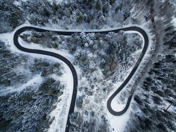 Aerial view of winding road in forest during winter