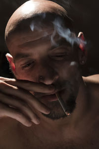 Close-up portrait of man smoking cigarette