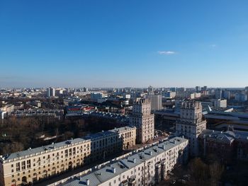 High angle view of city buildings against clear blue sky