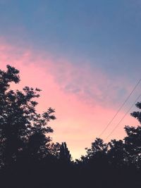 Low angle view of silhouette trees against romantic sky