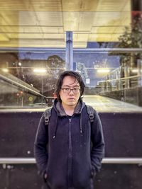 Portrait of young man standing in factory