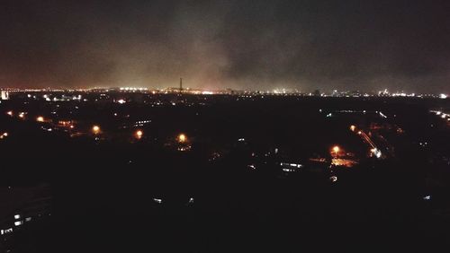 Illuminated city against sky at night