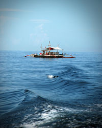 Ship sailing on sea against sky