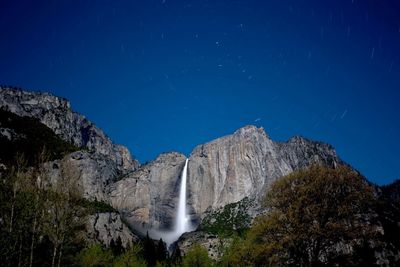 Scenic view of waterfall against sky at night