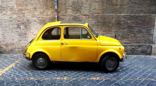 Side view of yellow car on street