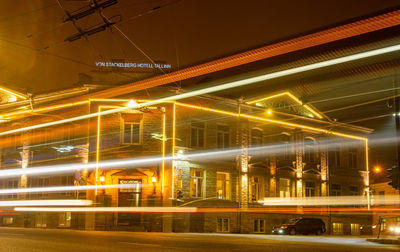 Low angle view of illuminated light trails on street at night