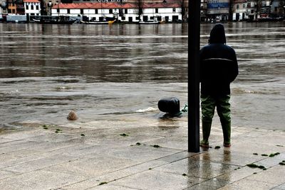 Rear view of man standing in water