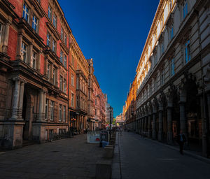 Street amidst buildings against clear sky