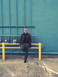 Full length portrait of man standing against wall