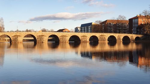 Arch bridge over river against sky