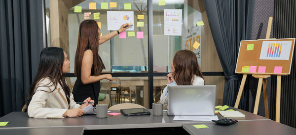 Side view of woman using mobile phone in office