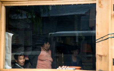 Portrait of smiling woman seen through glass window