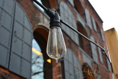 Low angle view of light bulb hanging on ceiling