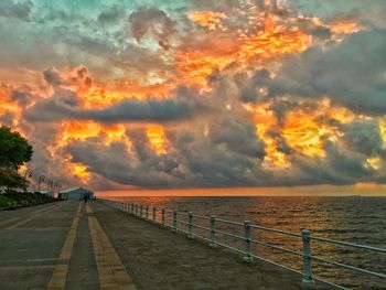 Scenic view of sea against dramatic sky during sunset