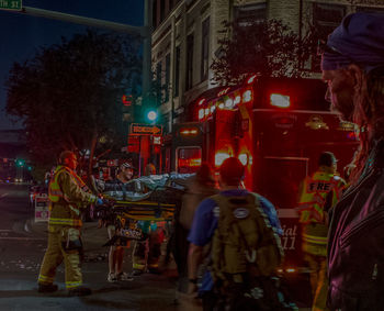 Rear view of people walking on street at night