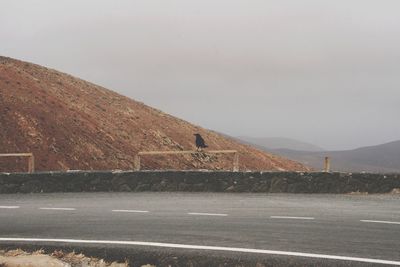 Road by mountain against clear sky