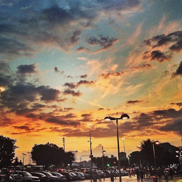 sunset, car, land vehicle, transportation, sky, mode of transport, street light, cloud - sky, silhouette, street, orange color, traffic, road, city, building exterior, cloudy, dramatic sky, built structure, architecture, parking lot