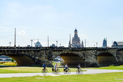 People cycling against augustus bridge